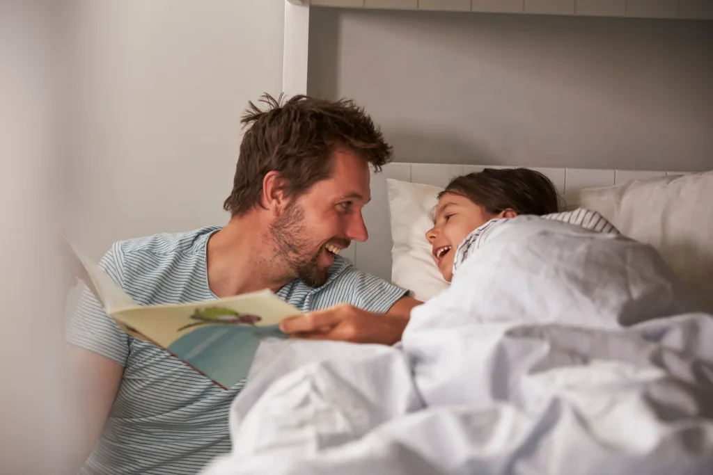 Father Reading Story To Daughter At Bedtime Why Sleep Is So Important for Kids