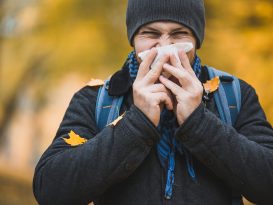 man sneezes and blows his nose in a handkerchief in an autumn;coping with fall allergies Tips for a Sneeze-Free Season By Annette Brooks