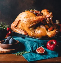 Roasted whole turkey on a table with apple, pumpkin and figs for family Thanksgiving Holiday