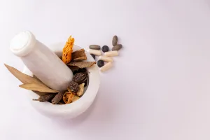 Top view of a mortar & pestle with whole spices to ground and sc Top view of a mortar & pestle with whole spices to ground and sc
