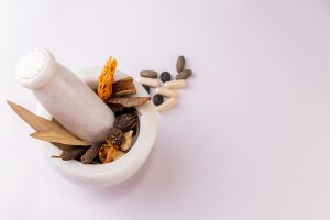 Top view of a mortar & pestle with whole spices to ground and sc Top view of a mortar & pestle with whole spices to ground and sc