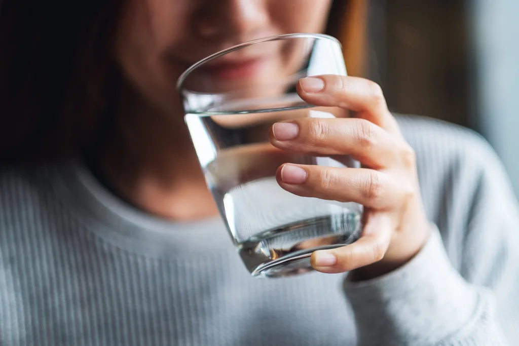 Closeup image of a beautiful young asian woman holding a glass of water; weather the cold Prepare Yourself for Cooler Temperatures