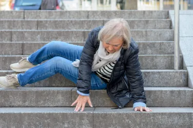 Senior woman falling down stone steps outdoors