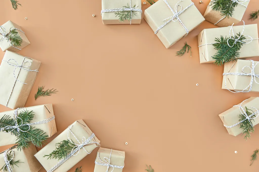Christmas gift boxes and fir tree on beige background