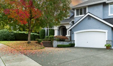 Early autumn residential single family home with colorful tree a