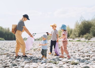 Volunteers family collecting plastic waste trash on river beach People help to keep nature clean up and pick up garbage Woman and kids helping clean up outdoor area from rubbish Teaching Children How to Care for Their Community