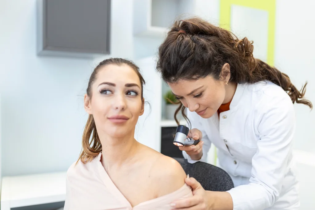 Dermatologist in latex gloves holding dermatoscope while examining attractive patient with skin disease Female dermatologist examining patient with dermascope, looking for signs of skin cancer; inspired
inspection
May is Skin Cancer and 
Melanoma Awareness Month