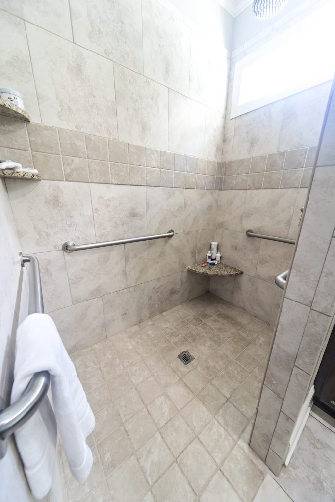 A large tiled handicap accessible shower with handrails A large tiled handicap accessible shower with handrails