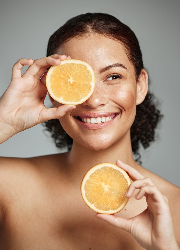Woman, smile and orange in studio for skincare, health and wellness with cosmetic glow, self care and backdrop Model, black woman and fruit for cosmetics, detox or healthy natural skin by background Woman, smile and orange in studio for skincare, health and wellness with cosmetic glow, self care and backdrop Model, black woman and fruit for cosmetics, detox or healthy natural skin by background