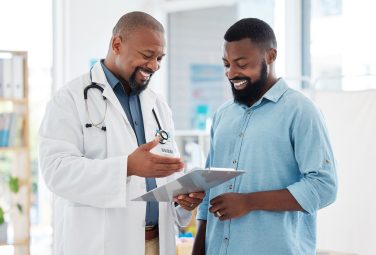 Healthcare, black man and doctor with clipboard, diagnosis and conversation for results, smile and care Male patient, guy and medical professional with documents, paperwork for insurance and talking