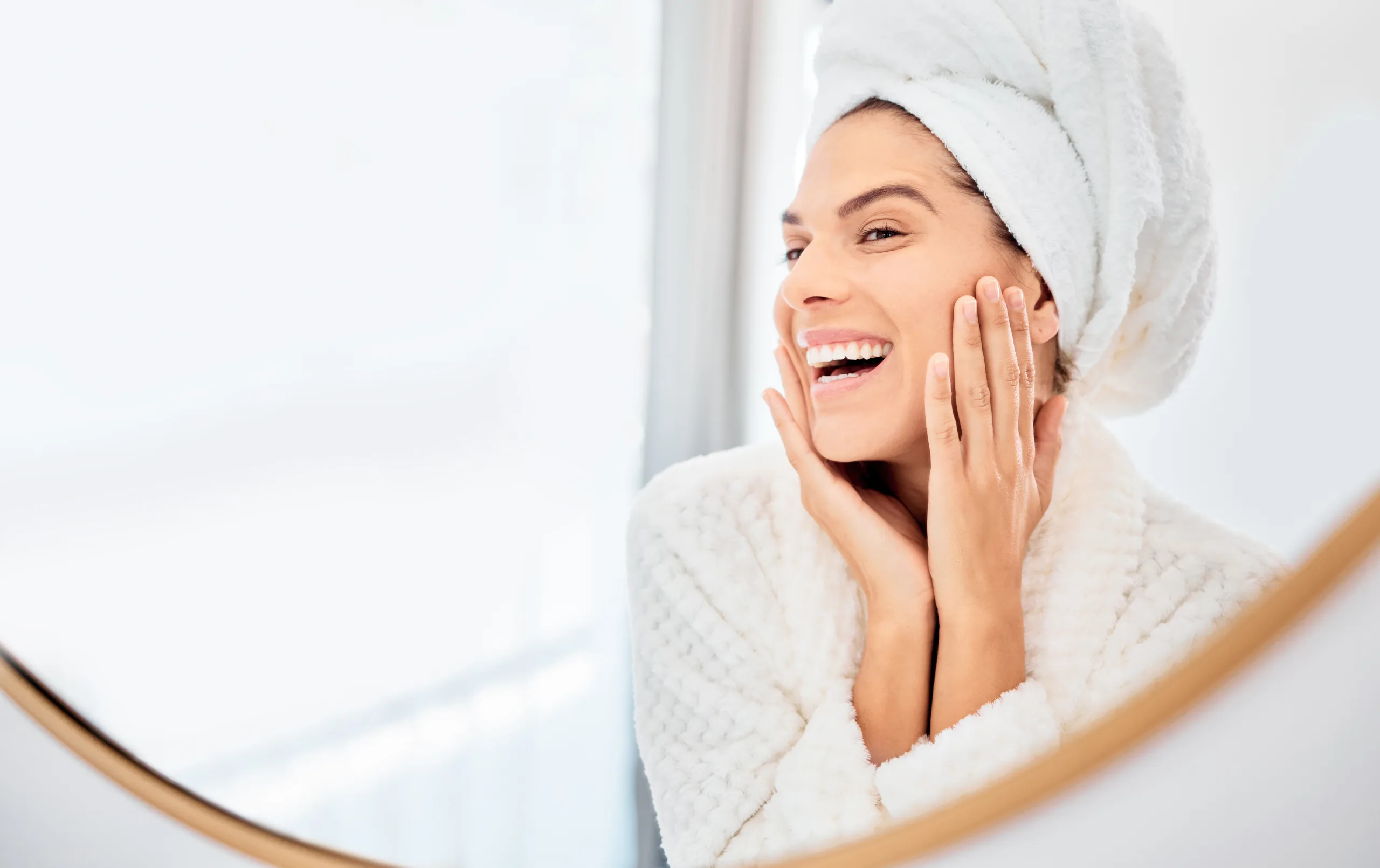 Mirror, happy woman and hands on face for skincare, smile and anti aging cosmetic result in bathroom Facial, beauty and female touch soft, glow or smooth skin from luxury dermatology routine at home making a splash Marine-Based Skincare Ingredients: Nourish, Smooth, Restore, and Hydrate