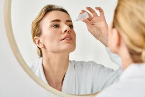 beautiful blonde woman with collected hair in bathrobe putting i beautiful blonde woman with collected hair in bathrobe putting i