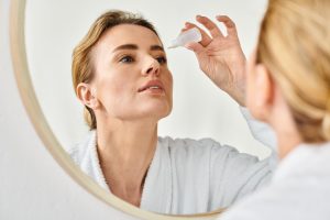 beautiful blonde woman with collected hair in bathrobe putting i beautiful blonde woman with collected hair in bathrobe putting i