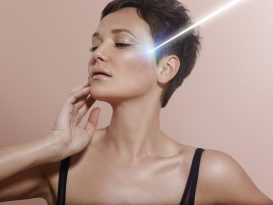 young woman with ideal skin and ray of laser on it