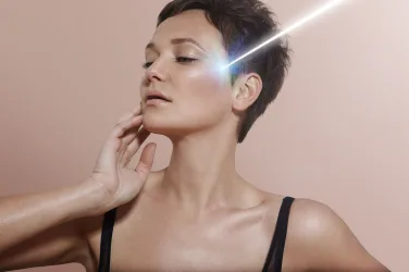 young woman with ideal skin and ray of laser on it