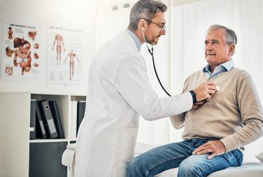 Men’s Health Month Don’t Delay Your Doctor Visits Consultation, man and doctor in office with stethoscope, checkup and healthcare at senior clinic Diagnosis, elderly patient and medical professional with support, checking heart health and advice