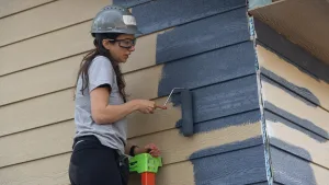 daughter of house owner helping to paint her own house being built by habitat for humanity