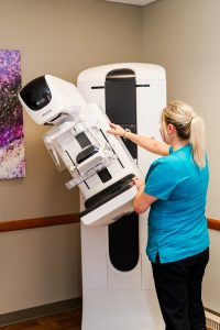nurse positions large imaging machine into place