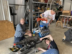 Craig Zale, Ret. Chief Gary Johnson & Nathan Reining mating new transmission to engine