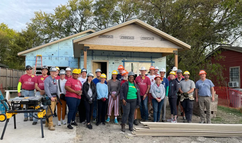 Habitat for Humanity crew of carpenters in front of 125th home build