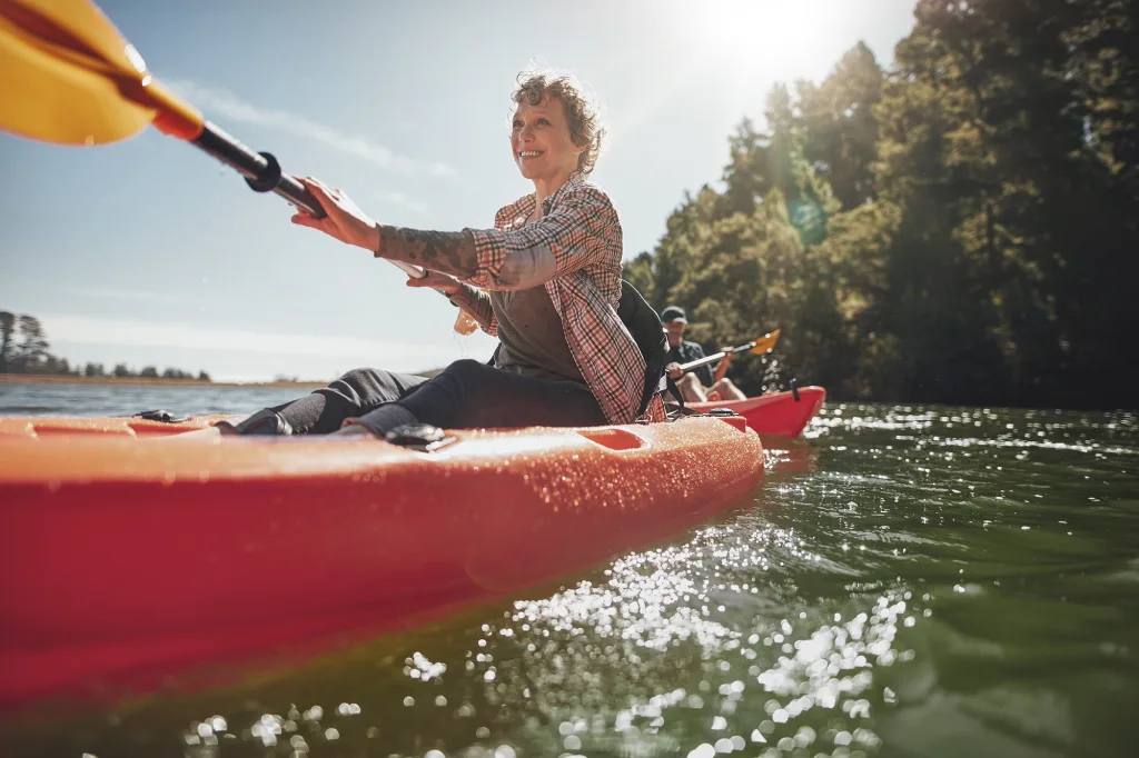 Shot,Of,Senior,Woman,Canoeing,In,Lake,On,A,Summer