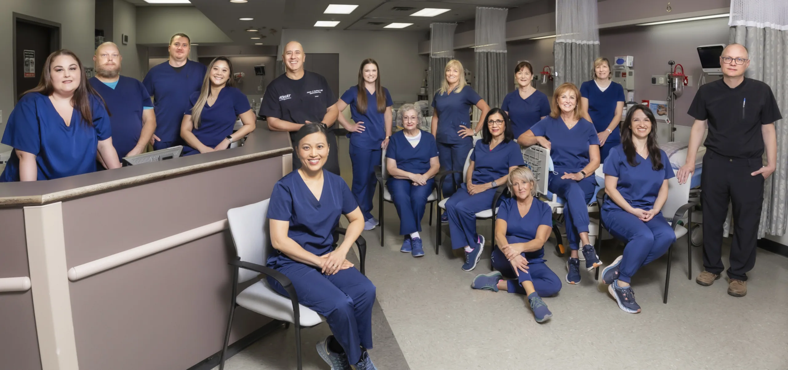 Digestive Health Center of Bedford staff poses for group photo wearing blue scrubs